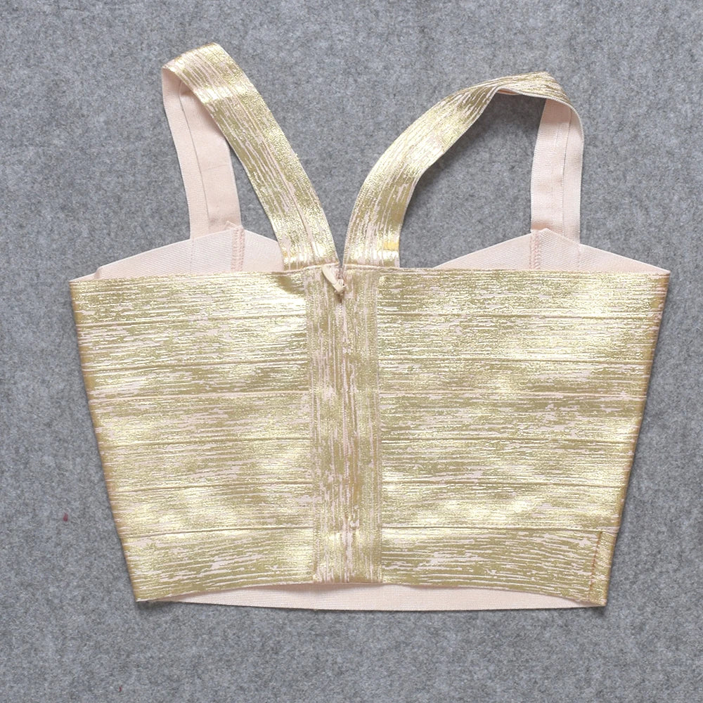 Gold metallic top with pink straps on a gray background