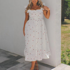 Woman wearing a white dress with red polka dots against a neutral background