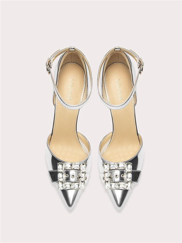 Pair of high-heeled shoes with embellishments on a light gray background