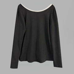 Black long-sleeve top with white neckline on a gray background