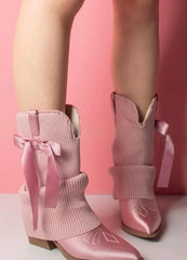 Pair of pink ribbed knit slouchy boots with satin pointed toe and bow accent.
