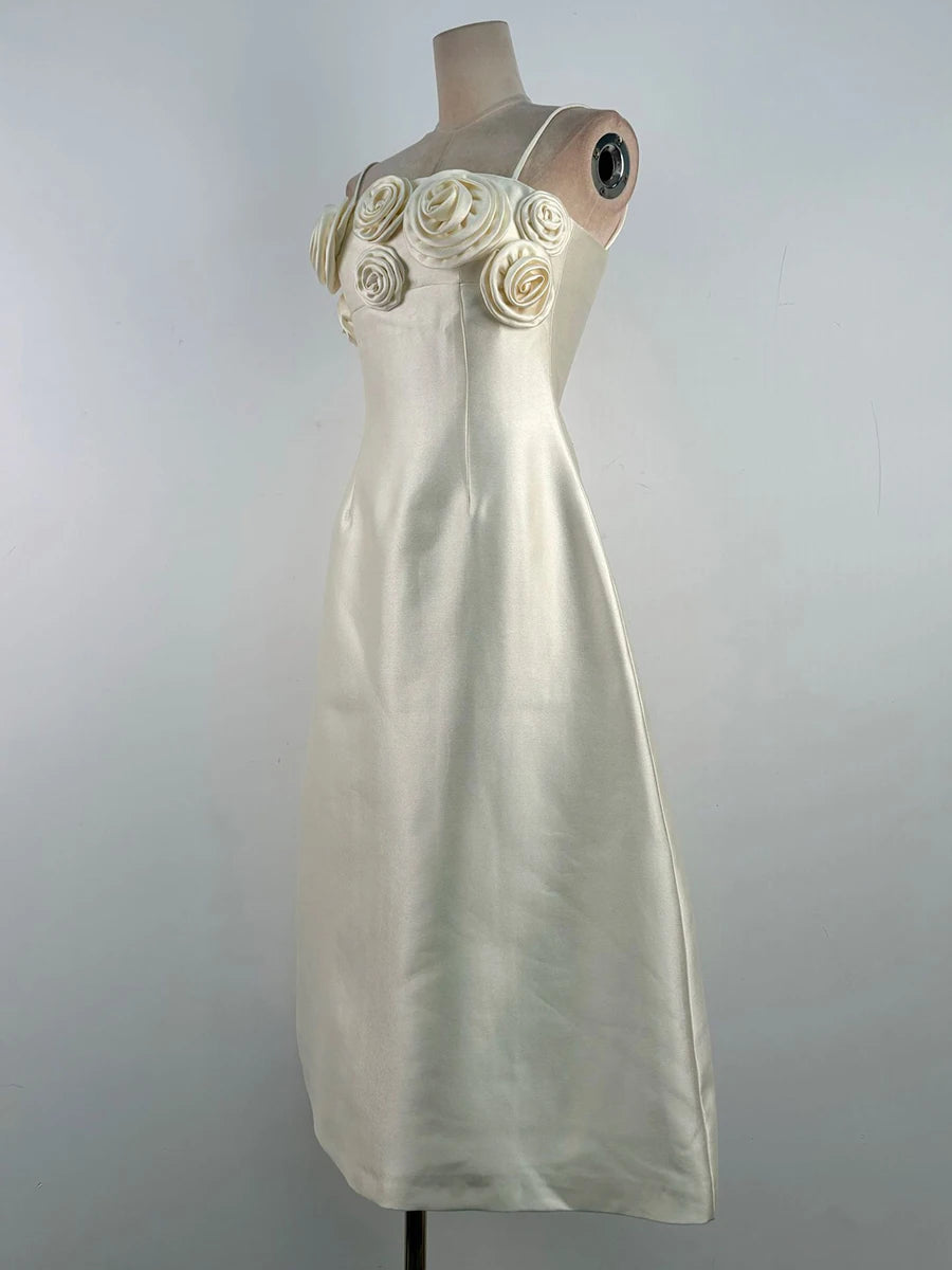 White dress with floral details on a mannequin against a gray background