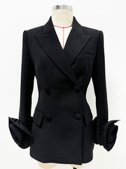 Sculpted double-breasted black blazer with dramatic floral cuffs shown on a mannequin.