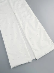 Two white mattress toppers with small gray dots on a gray background