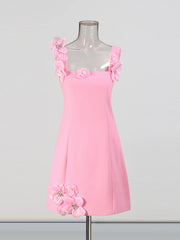 Pink dress with floral embellishments on a mannequin against a gray background