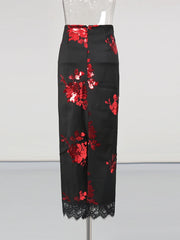 Black pants with red floral sequin embellishments on a mannequin against a white background