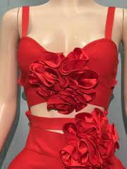 Red dress with floral embellishments on a mannequin against a gray background