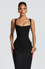 Woman wearing a black dress against a plain background