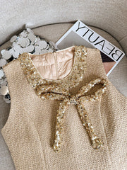 Beige top with gold sequin details on a textured surface