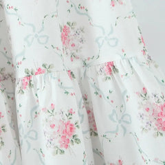Floral patterned fabric with pink flowers and green leaves on a white background