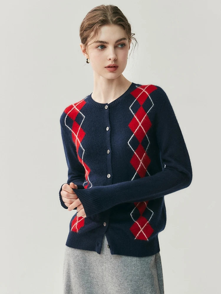 Woman wearing a navy blue cardigan with red and white diamond pattern on a light gray background