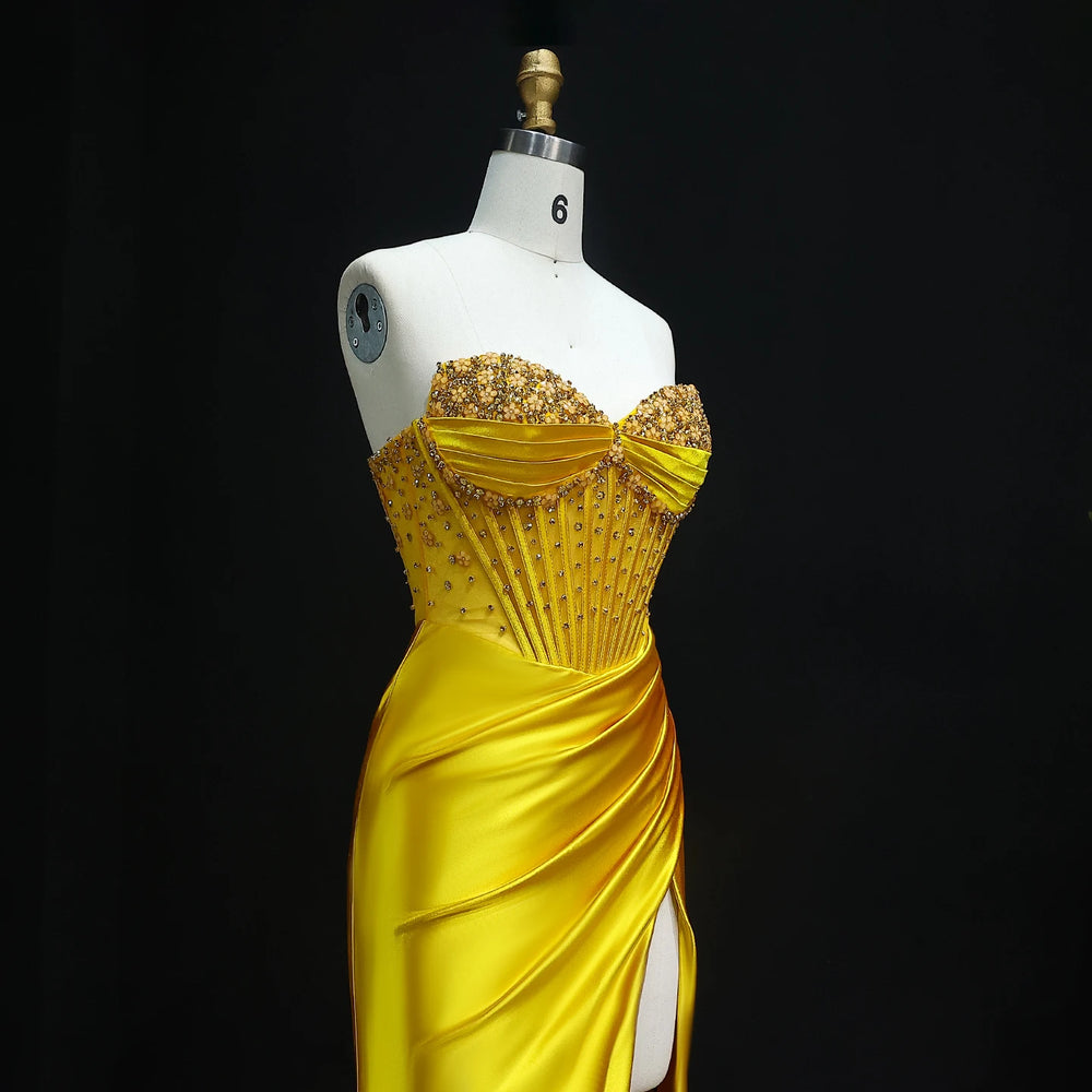 Yellow evening gown on a mannequin against a black background