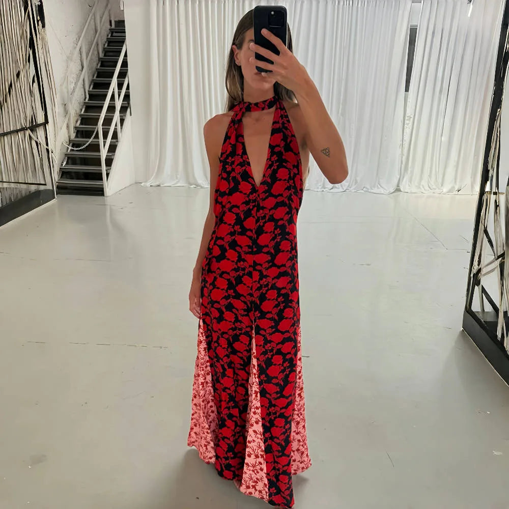 Person wearing a red and black floral dress in a minimal indoor setting.