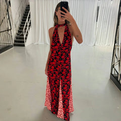 Person wearing a red and black floral dress in a minimal indoor setting.