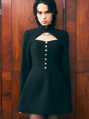Woman wearing a black dress with cut-out design against a wooden background