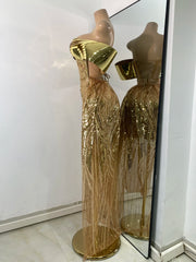 Gold sequin evening gown on a mannequin with a mirror reflection.
