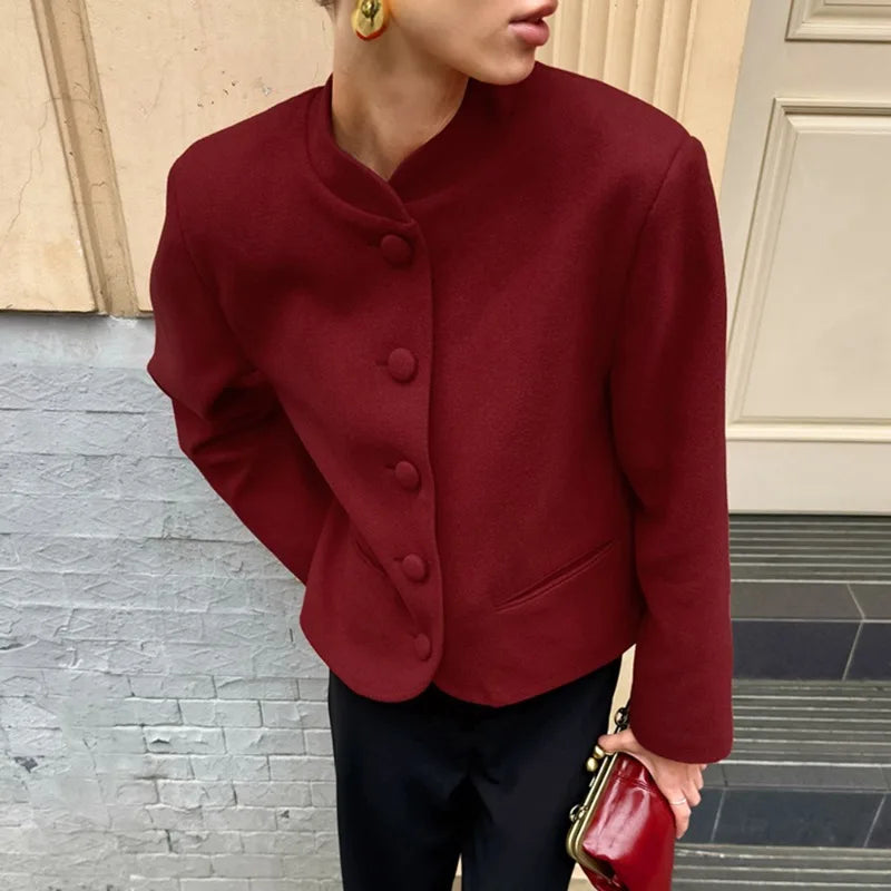 Person wearing a red jacket with a neutral background