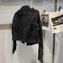 Back view of a black denim jacket with a stand-up collar and long sleeves.