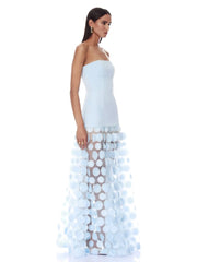 Woman wearing a strapless light blue gown with a unique skirt design on a white background