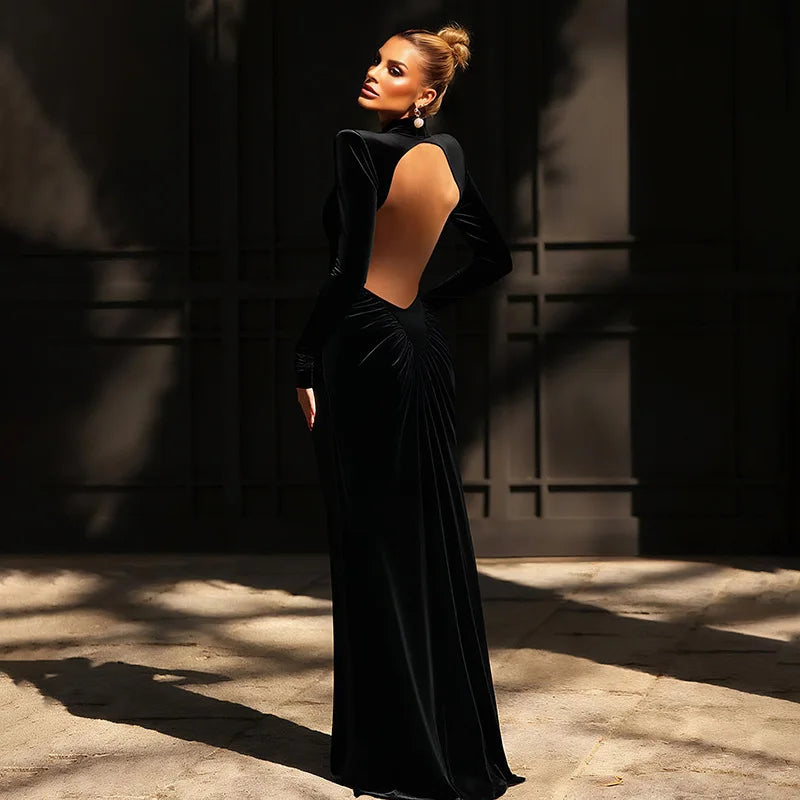 Woman in a black evening gown standing in a sunlit outdoor setting