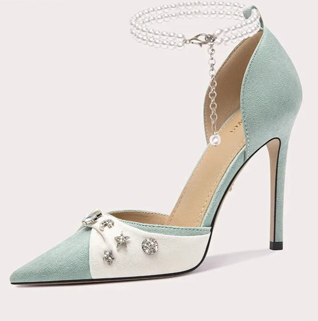 Mint green and white high-heeled shoe with decorative elements on a white background
