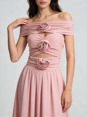 Pink off-shoulder dress with floral details on a plain background