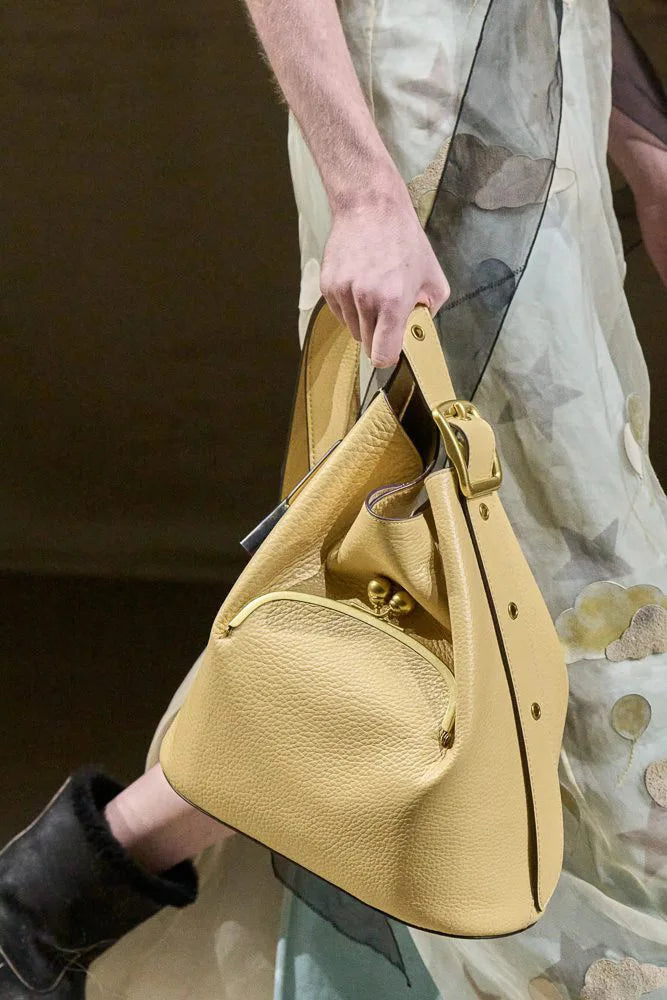 Yellow handbag held by a person with a blurred background