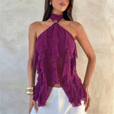 Woman wearing a purple ruffled dress against a neutral background