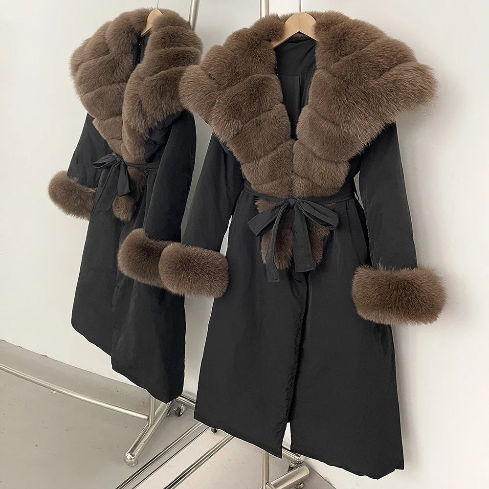 Black coat with brown fur trim on a rack against a white wall