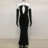 Black evening gown with gold embellishments on a mannequin against a white background