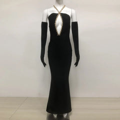 Black evening gown with gold embellishments on a mannequin against a white background
