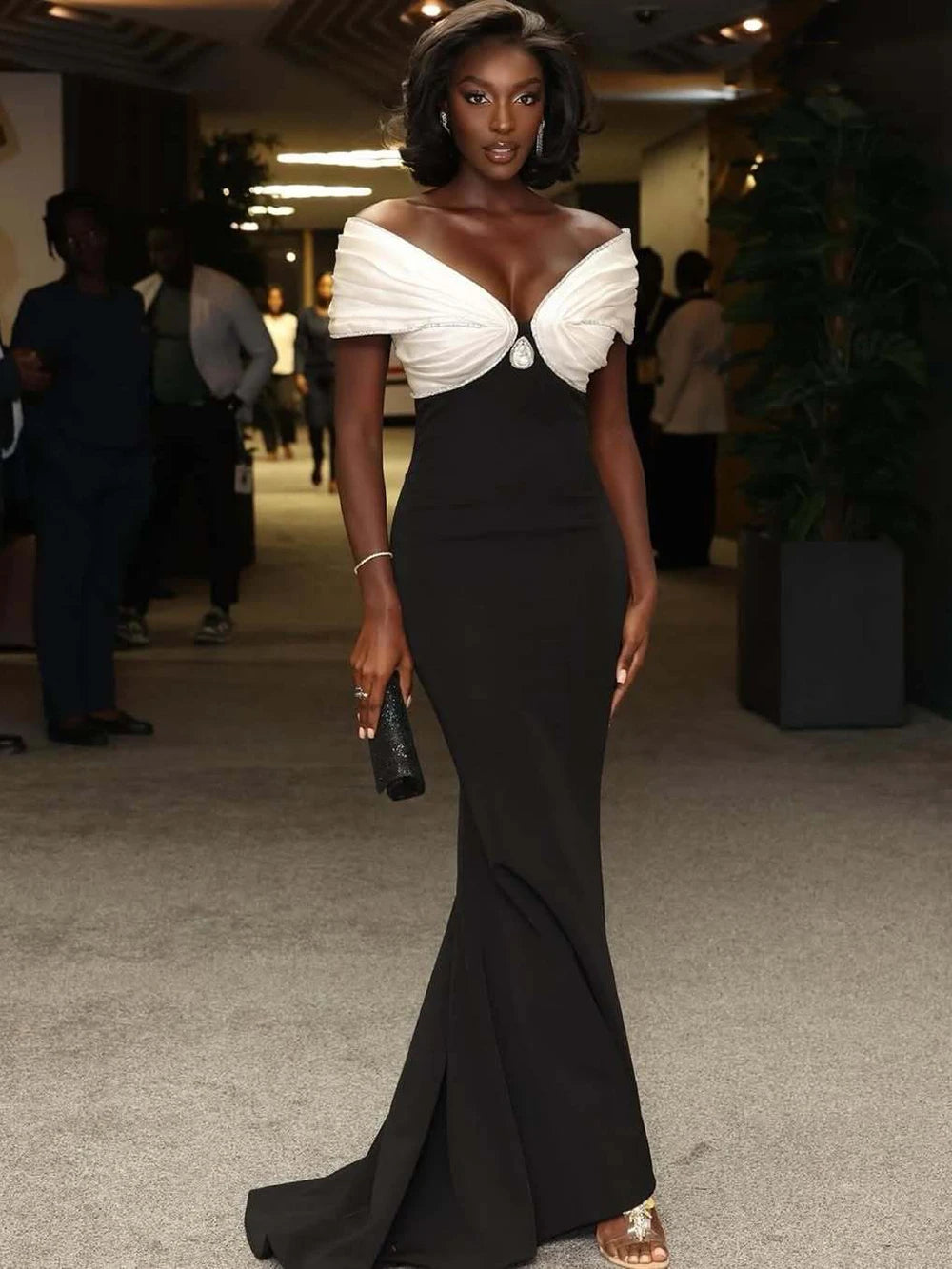 Woman in a black and white evening gown at an indoor event.
