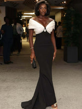 Woman in a black and white evening gown at an indoor event.