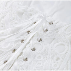 Close-up of white textured fabric with metal rings.