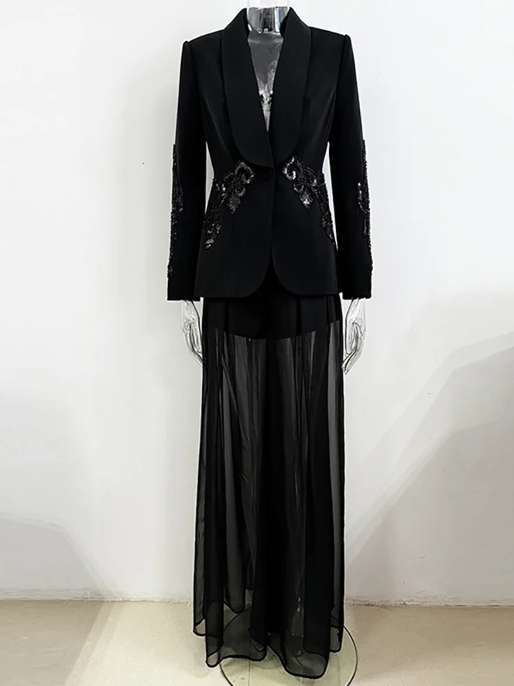 Black formal outfit with a jacket and sheer skirt on a mannequin against a white background
