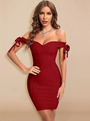 Woman wearing a red off-shoulder dress with bows on a beige background