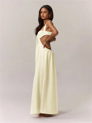Woman wearing a white jumpsuit with a cut-out design on a plain background