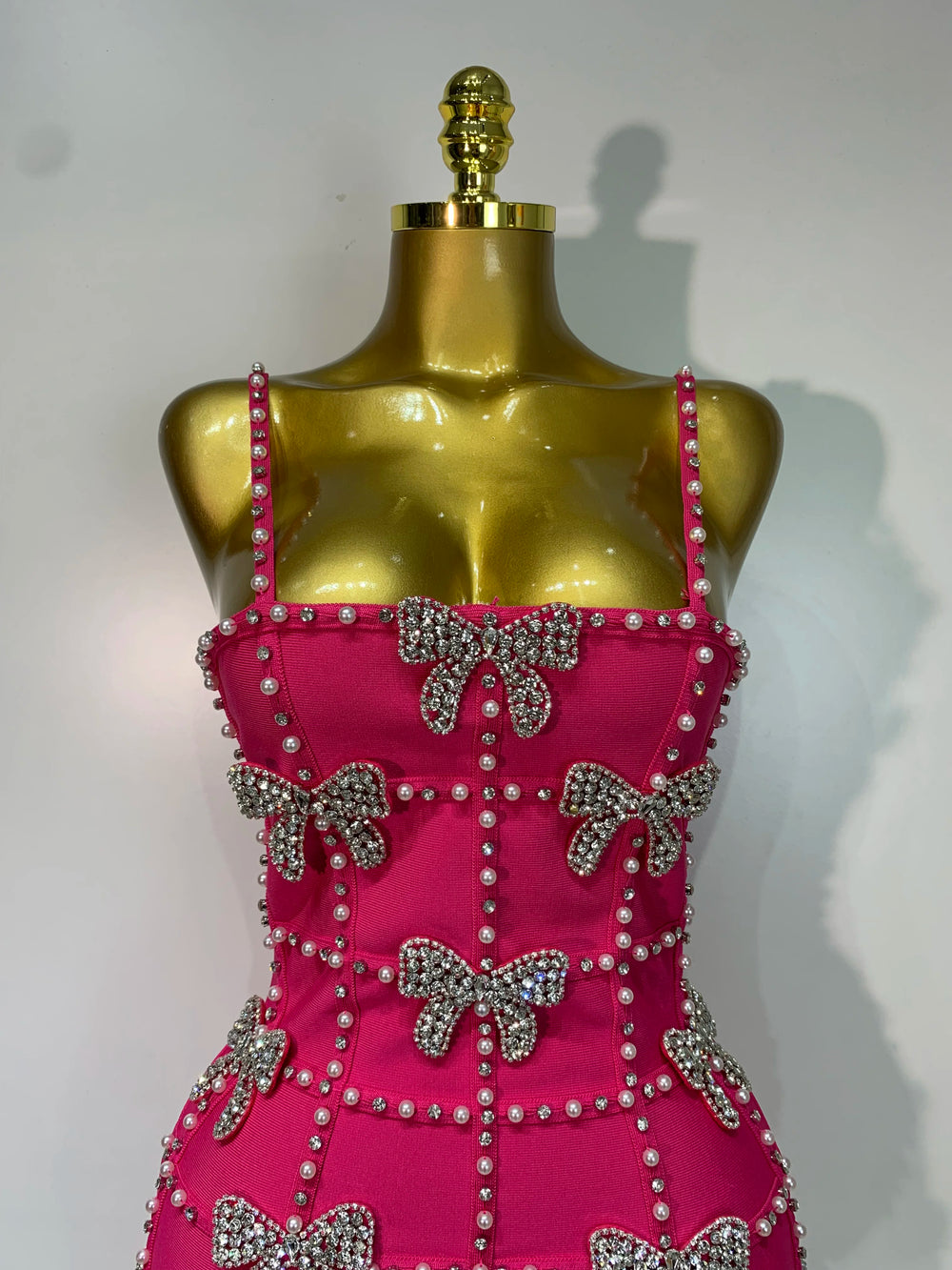 Front detail of sleeveless beaded bow mini dress