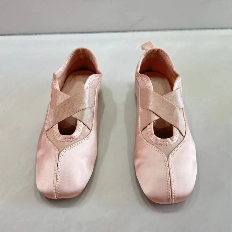 Top view of pink satin ballet flats with crisscross straps
