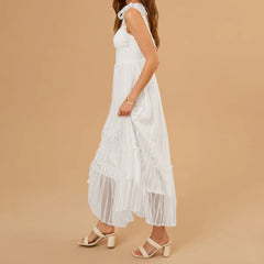 Woman wearing a white dress with ruffled details on a beige background