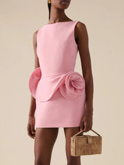 Pink dress with a bow detail worn by a model on a beige background
