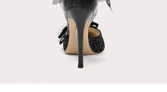 Black high-heeled shoe with a bow on a white background