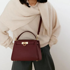 Burgundy structured top handle bag on a model.