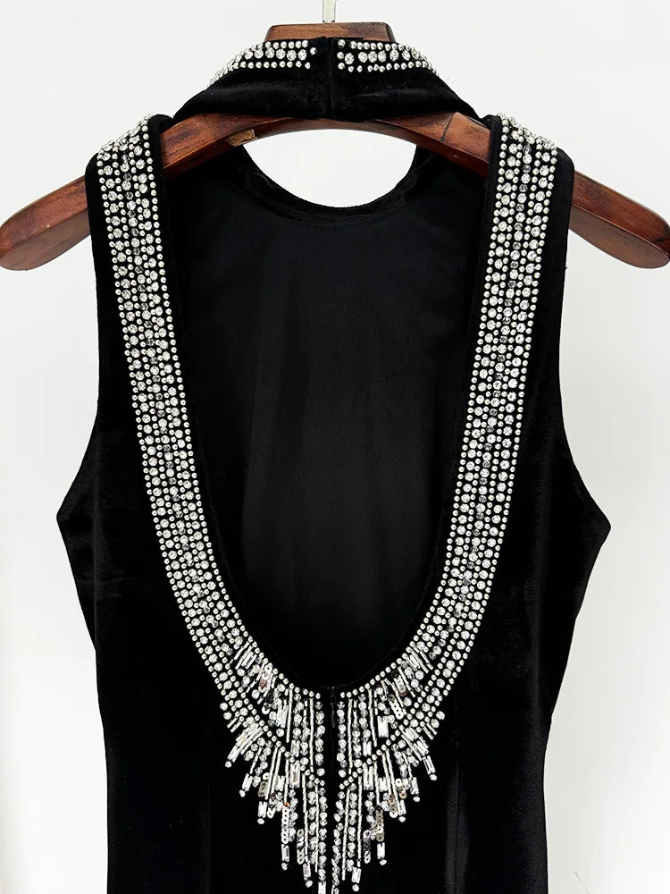 Black sleeveless top with decorative white stones on a wooden hanger against a white background