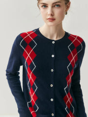 Person wearing a navy cardigan with red and white argyle pattern on a light gray background