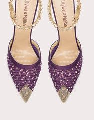 Purple high-heeled shoes with gold accents on a white background