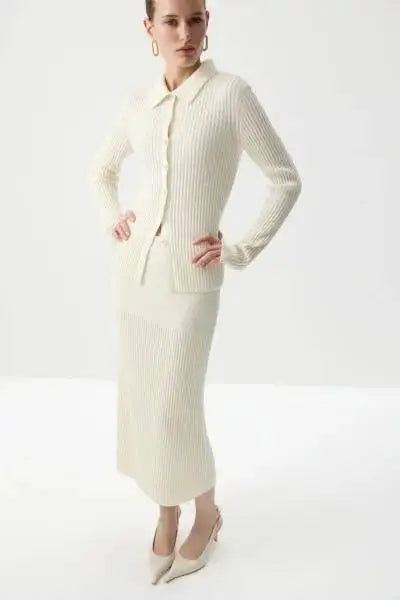 Model posing in cream ribbed knit polo top and midi skirt