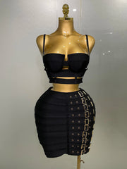 Black dress with cut-out design on a gold mannequin against a white background