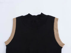 Black sleeveless top with beige arm bands on a white background