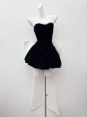 Black strapless dress on a mannequin against a white background